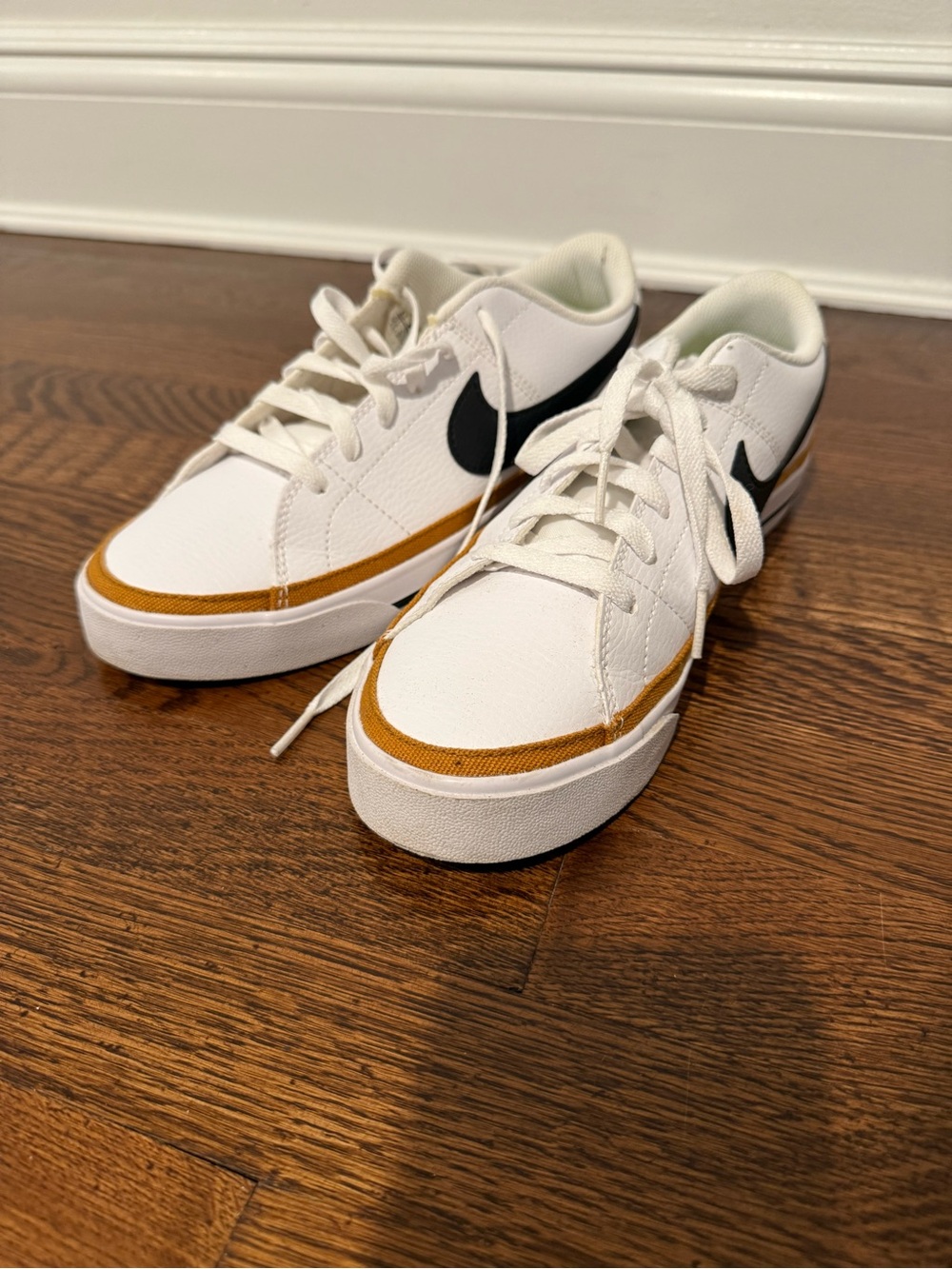 Nike White Low-Top Sneakers with Black Swoosh and Brown Accent